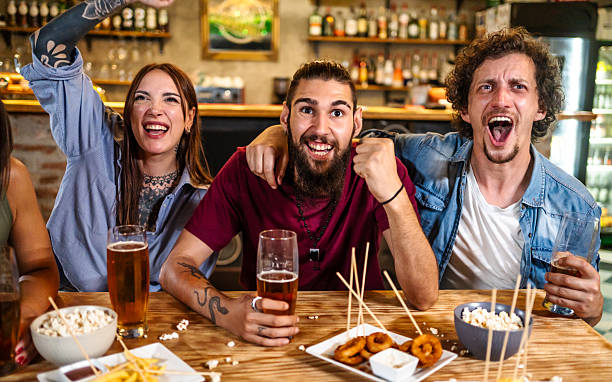 istock Excited friends watching soccer game at pub, cheering and drinking beer 2225193771