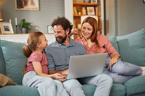 istock Happy family using laptop together on sofa at home 2225195789