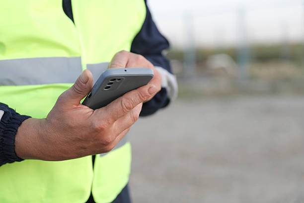 istock Industrial Worker Using Phone At Oil Extraction Site 2225198439