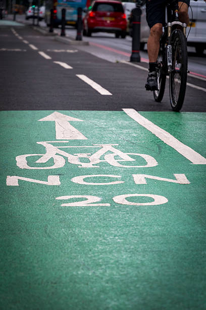 istock Green cycle lane with cyclist riding by busy road 2225199175