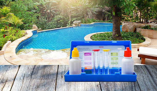 istock Water testing test kit on wooden table over free flow sahpe swimming pool 2225204660