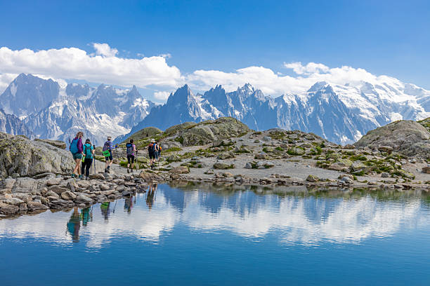 Chamonix, France - 08 August, 2024: Happy hiker on the trekking mountain path Tour du Montblanc. Beautiful alpine landscape of the French and Italian Alps. Hikers in the Alps enjoy the nature and mountains