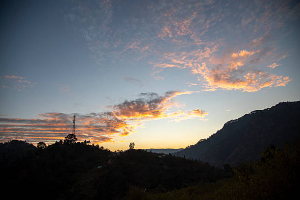 istock Cell Tower Amidst Glowing Hillside Sunset in Uttarakhand Village Landscape 2225207921
