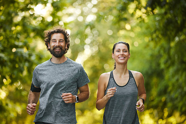 istock Smiling adults jogging through a lush park 2225209192