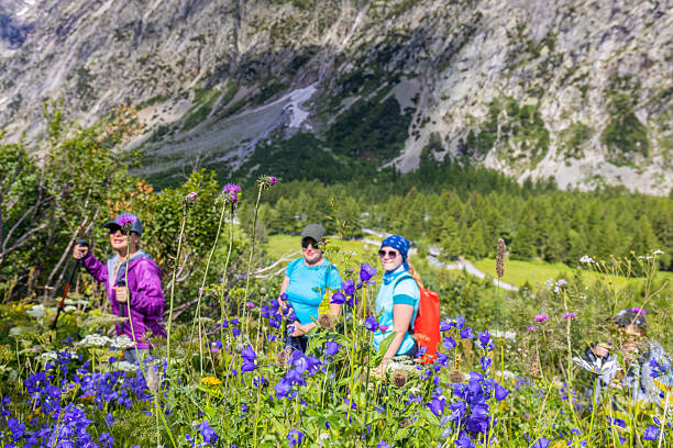 Chamonix, France - 08 August, 2024: Happy hiker on the trekking mountain path Tour du Montblanc. Beautiful alpine landscape of the French and Italian Alps. Hikers in the Alps enjoy the nature and mountains