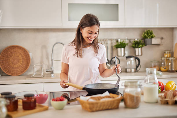 istock Young woman cooking breakfast in a modern kitchen 2225210035