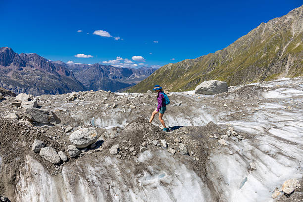 Chamonix, France - 08 August, 2024: Happy hiker on the trekking mountain path Tour du Montblanc. Beautiful alpine landscape of the French and Italian Alps. Hikers in the Alps enjoy the nature and mountains