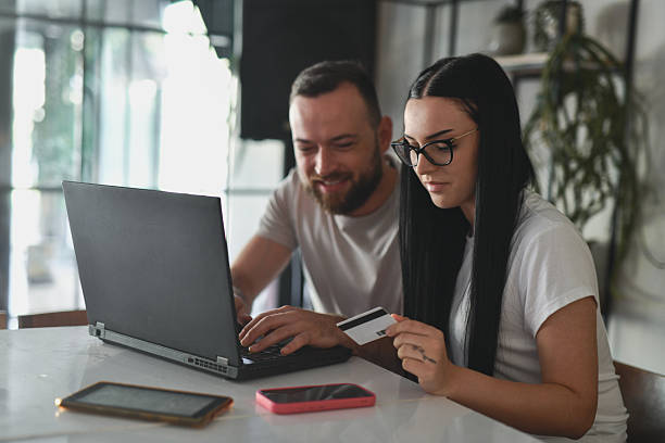 istock Couple Making Hotel Reservation With Credit Card While Sitting Side By Side In Coffee Shop 2225210874