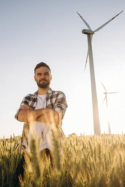 istock Beautiful nature. Guy engineer in wheat field against wind turbines 2225211473
