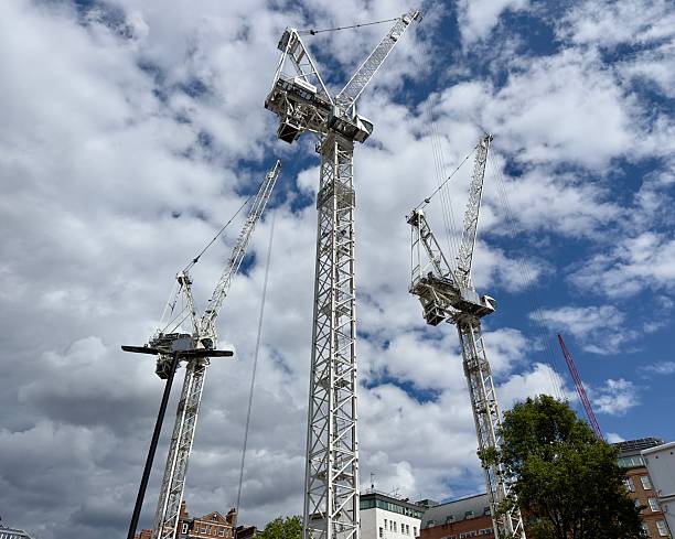 London, UK - May 28, 2025: Construction cranes soaring into the sky above a building site in Mayfair, London, England.
