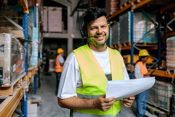 istock Warehouse worker posing for camera while holding paperwork near storage shelves 2225213615