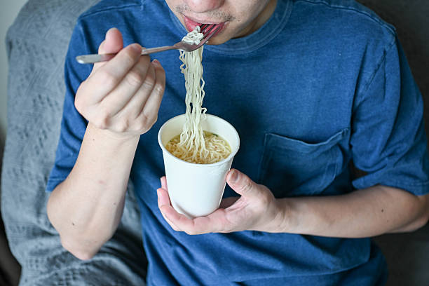 istock Easy Dining: Enjoying Instant Noodles on the Couch 2225214840