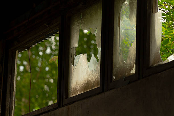 istock A broken window that beautifully reflects the surrounding trees in it 2225218240