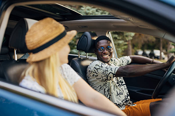 istock A smiling black man is driving a car during a summer trip with his girlfriend 2225218277