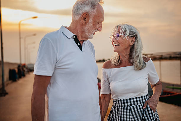 istock Senior couple enjoying a romantic evening stroll along the beach during sunset 2225218283