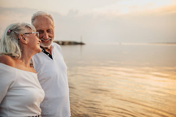 istock Senior couple enjoying romantic moments by the beach during sunset while on vacation 2225220889