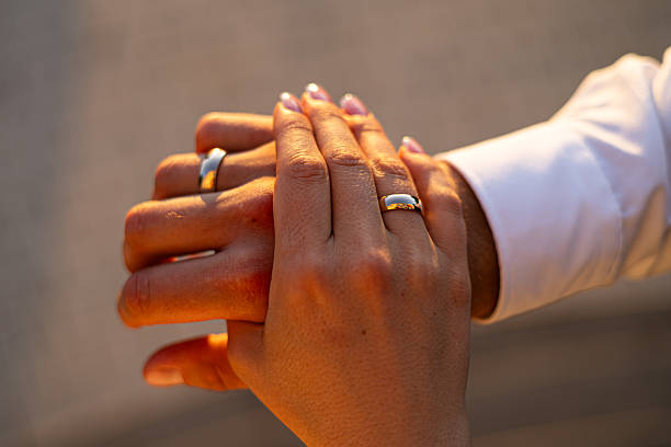 istock Hands Joined in Love Wearing Wedding Rings at Sunset 2225223162