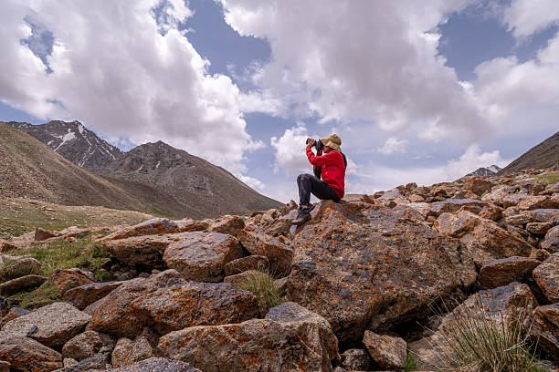 Hiker carefully frames the scene through a camera mountains during an adventurous hike emotional and visual experience that connects the traveler with the landscape