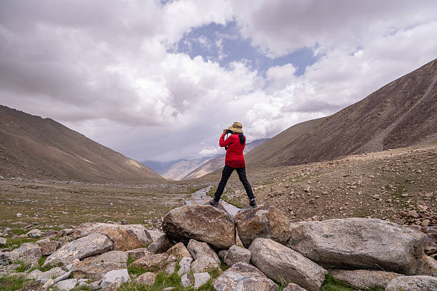 Hiker carefully frames the scene through a camera mountains during an adventurous hike emotional and visual experience that connects the traveler with the landscape.