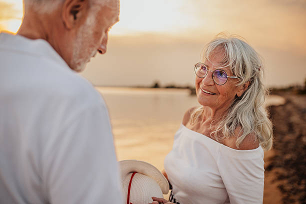 istock Senior couple enjoys a romantic sunset on the beach during their vacation while embracing love and happiness 2225224454