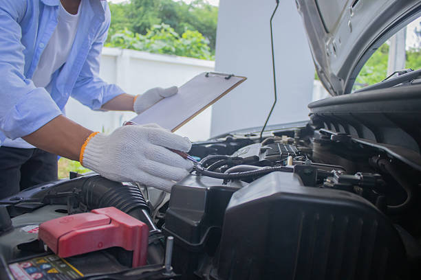 istock Technician in uniform inspecting car with clipboard, focusing on checklist, damage assessment, insurance claim, repair procedure, maintenance report, tools, transportation, expertise, service, office, work, safety 2225226013