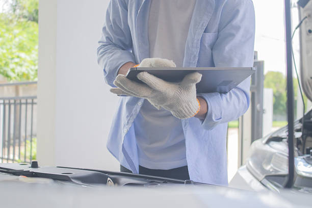 istock Technician in uniform inspecting car with clipboard, focusing on checklist, damage assessment, insurance claim, repair procedure, maintenance report, tools, transportation, expertise, service, office, work, safety 2225226079
