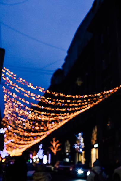istock Warm string lights illuminate a festive street during evening hours in a city celebration 2225227362