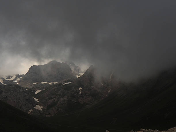Woman walking backwards in a landscape with snow-covered mountains