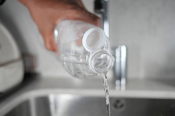 istock Pouring clear water from a plastic bottle into a kitchen sink 2225230357