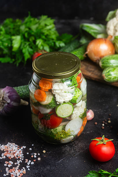 istock Assorted canned vegetables in a glass jar close-up. Pickled vegetables 2225230760
