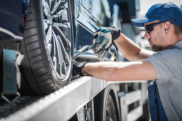 istock Worker Securing Vehicle on Tow Truck in Bright Daylight 2225232337
