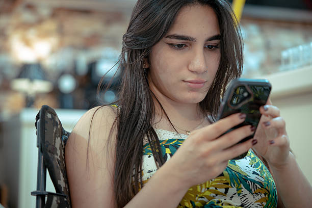 istock Young woman texting on smartphone at home 2225235419