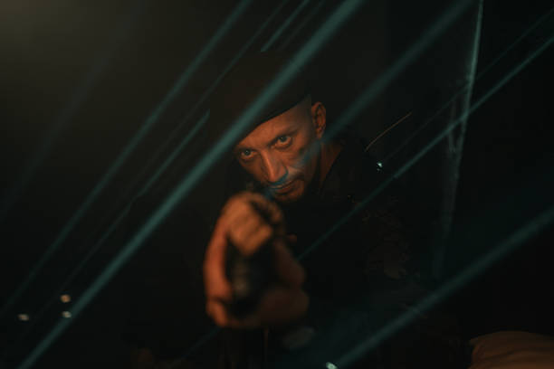 Surreal photo of a person against a dramatic backdrop, illuminated by strong lighting elements, emphasizing mystery and intensity.