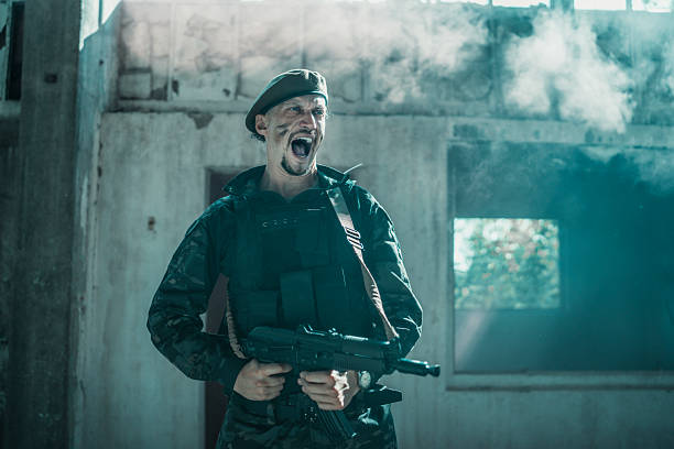 A soldier in tactical gear shouting passionately while holding a rifle, set in an abandoned area filled with natural light filtering through windows and creating dramatic contrast with shadows and dust particles.