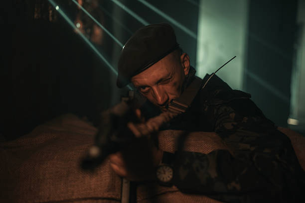 istock Military Officer in Tactical Gear Aiming Rifle with Focused Expression 2225236003