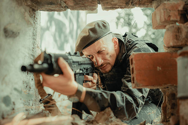 istock Soldier Aiming Rifle Through Rubble with Tactical Precision and Focus 2225236027