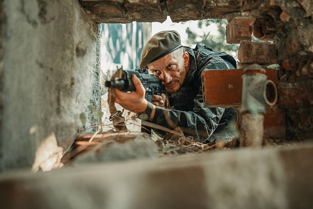 istock Military Soldier Aiming Through Ruins in Engaging Tactical Scene 2225236032