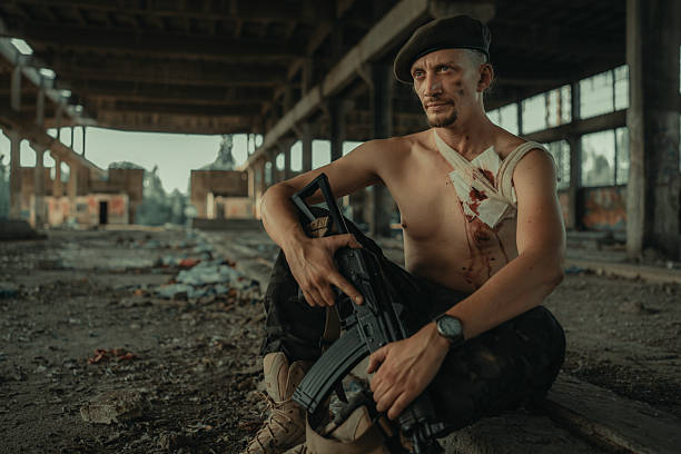 istock Wounded Soldier Resting in Abandoned Building with a Rifle 2225236143