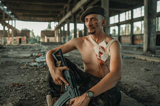 istock Injured Soldier Resting in an Abandoned Building with Weapon 2225236155