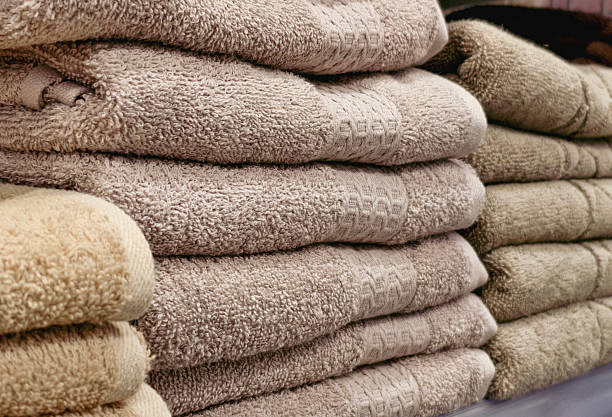 White towels hanging in front of tiled bathroom wall