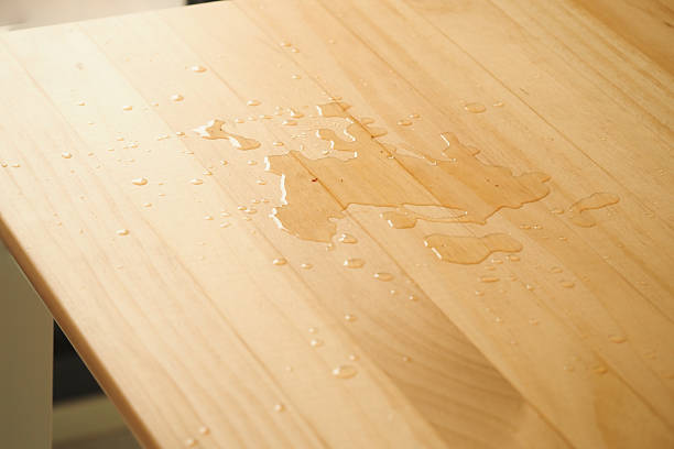 istock Water spilled on a wooden table surface in natural light 2225238656