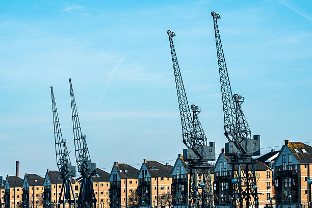 A container terminal with tall cranes with a nuclear power station in the background. Night shot taken in Antwerp, Belgium.