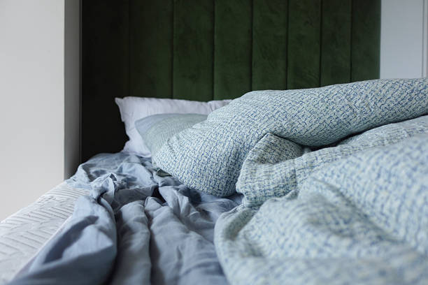 istock messy bed with soft blankets at early morning 2225240546