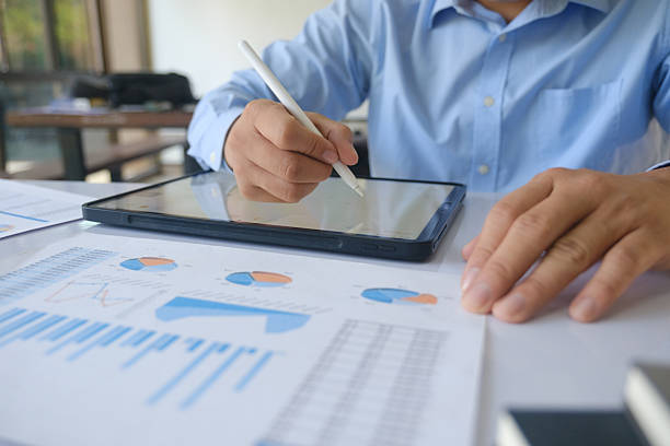 istock Businessman analyzing financial data on tablet with stylus during office meeting. 2225245294
