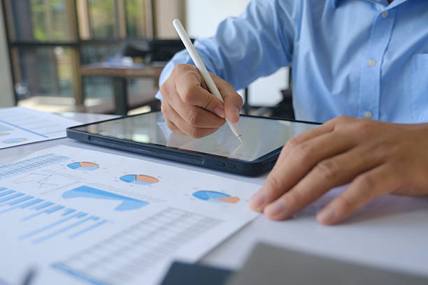 istock Businessman analyzing financial data on tablet with stylus during office meeting. 2225245302