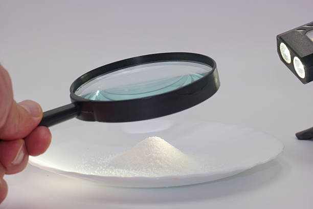 istock Examining sugar granules with a magnifying glass and light at a research lab 2225247446