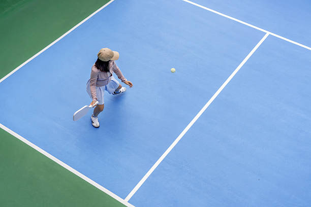 istock woman bouncing ball in pickleball game 2225248331