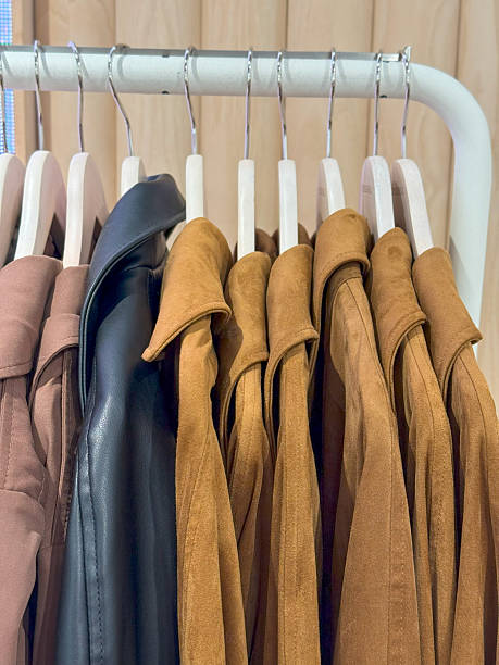 istock Neutral Toned Clothing Rack with Jackets, Sweaters, and Shirts on Hangers 2225258129