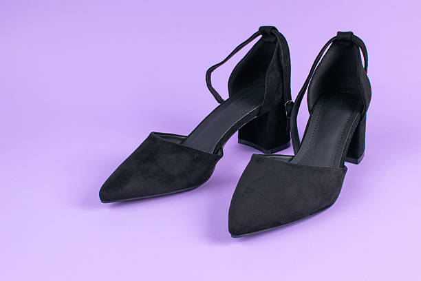 istock Elegant Black Suede Ankle Strap Heels on Minimalist Purple Background 2225260311