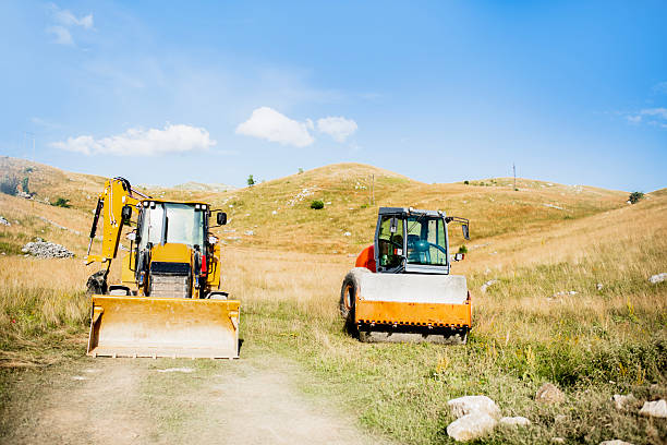 Yellow road roller parked on construction site